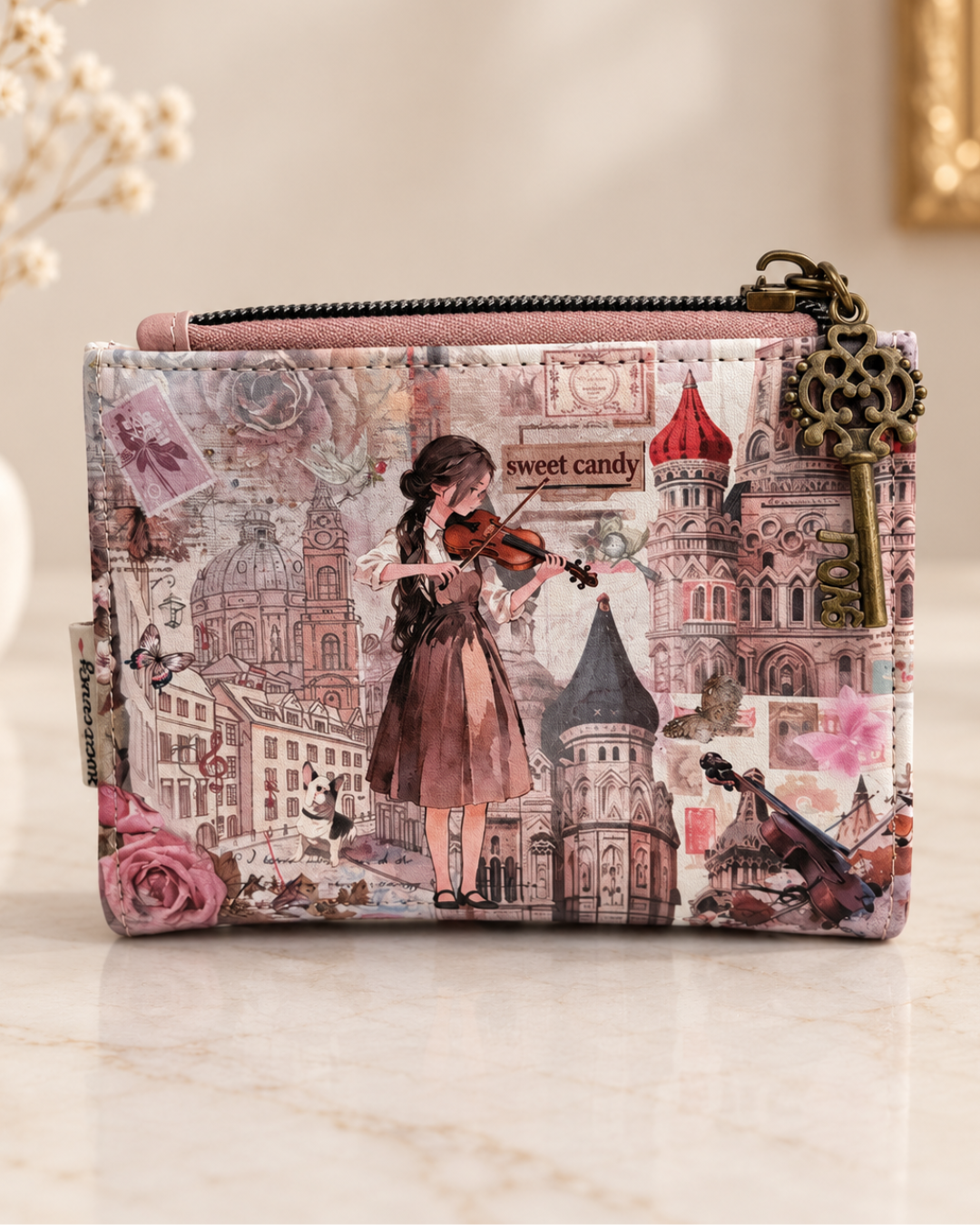Cartera Sweet Candy con ilustración de violinista, edificios y flores, cremallera superior y tirador de llave en tono bronce.