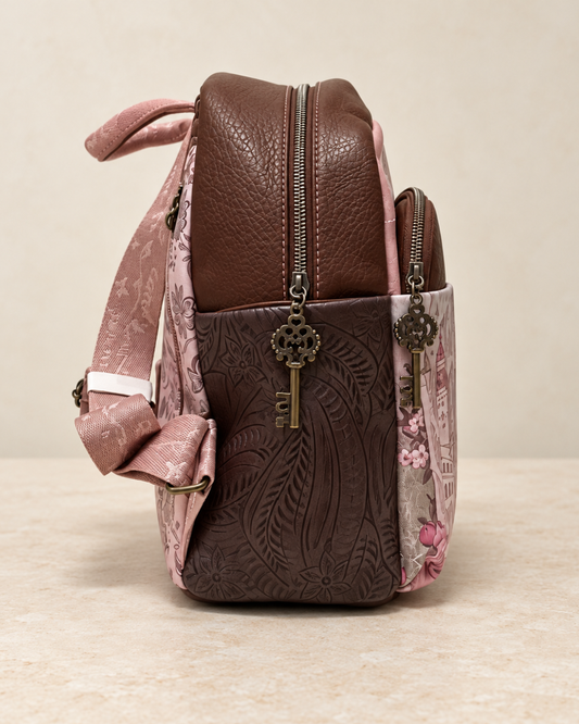 Vista lateral de mochila Sweet Candy marrón y rosa con hojas en relieve y tiradores de cremallera con forma de llave.