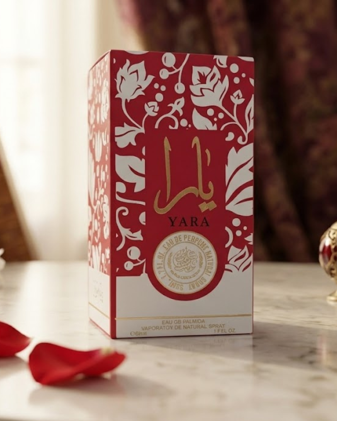Perfume Yara Red Eau de Parfum de 50 ml en estuche rojo sobre mesa de mármol con pétalos de rosa.