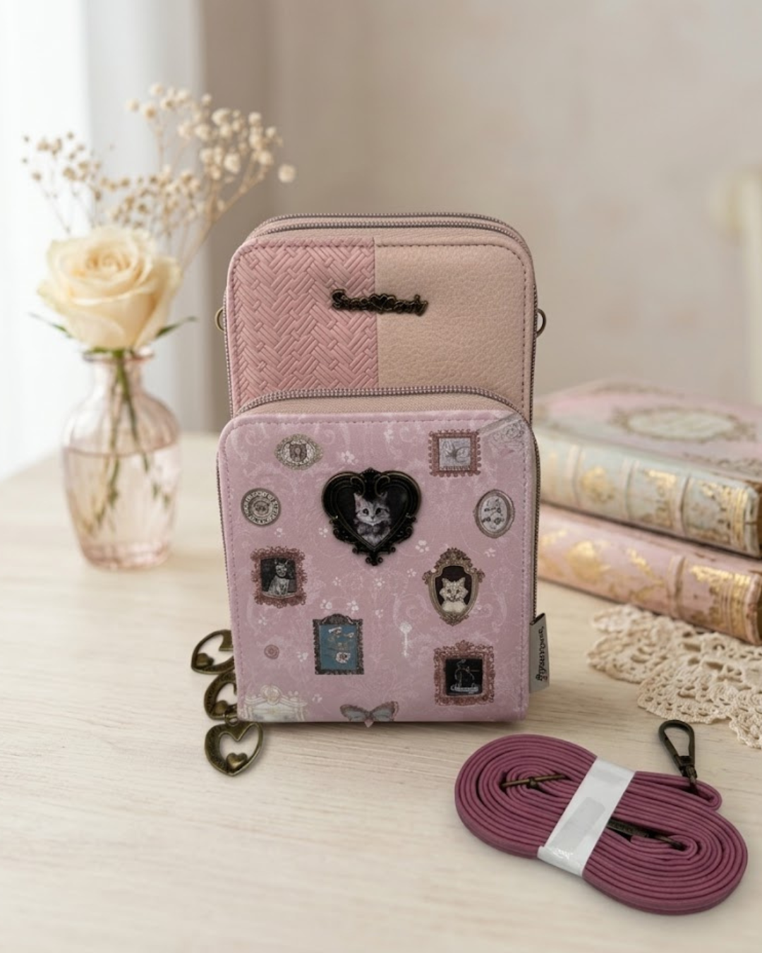 Bolso portamóvil Sweet Candy rosa con estampado de gatitos victorianos y correa bandolera sobre mesa de tocador.