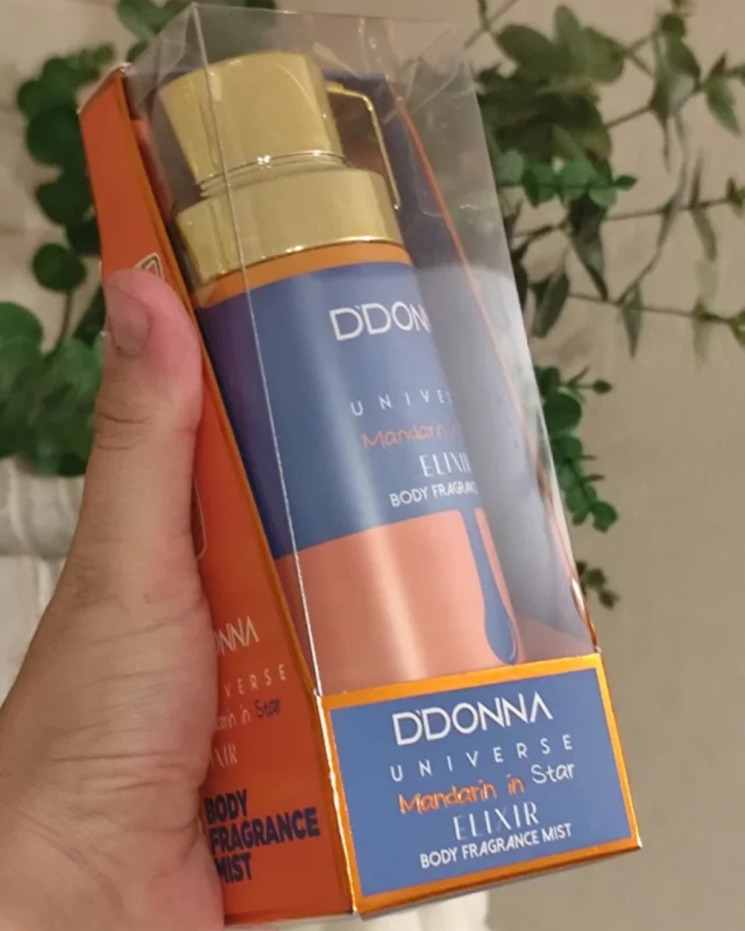 Frasco de bruma corporal D'Donna Universe Mandarin in Star Elixir de 250ml en envase azul y naranja con tapón dorado.