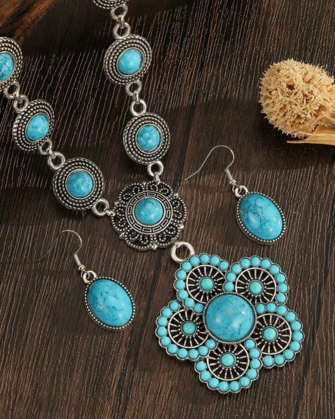 Juego de bisutería boho estilo étnico con collar y pendientes de piedras turquesas sobre fondo de madera.