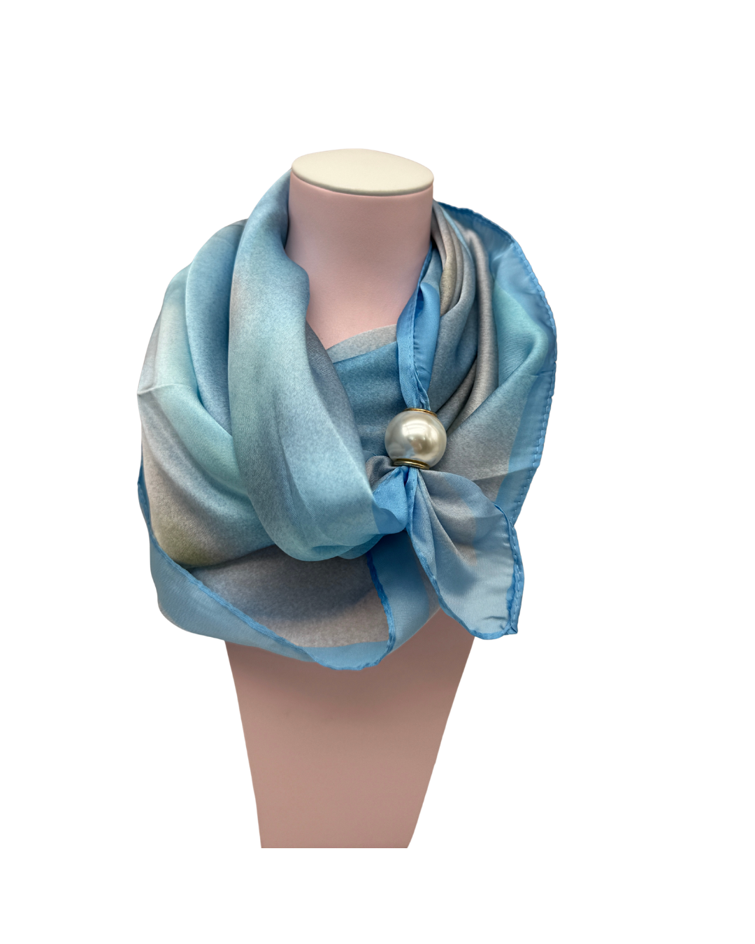 Detalle de pañuelo satinado azul y gris con accesorio de perla de alta calidad sobre fondo neutro.