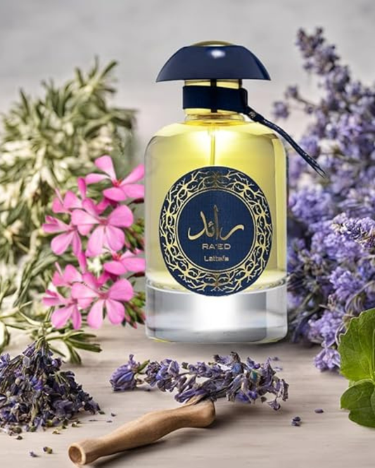El frasco de Lattafa Ra'ed Luxe en un bodegón natural rodeado de flores de lavanda, geranios rosas y ramitas de romero, sugiriendo sus notas aromáticas y frescas.