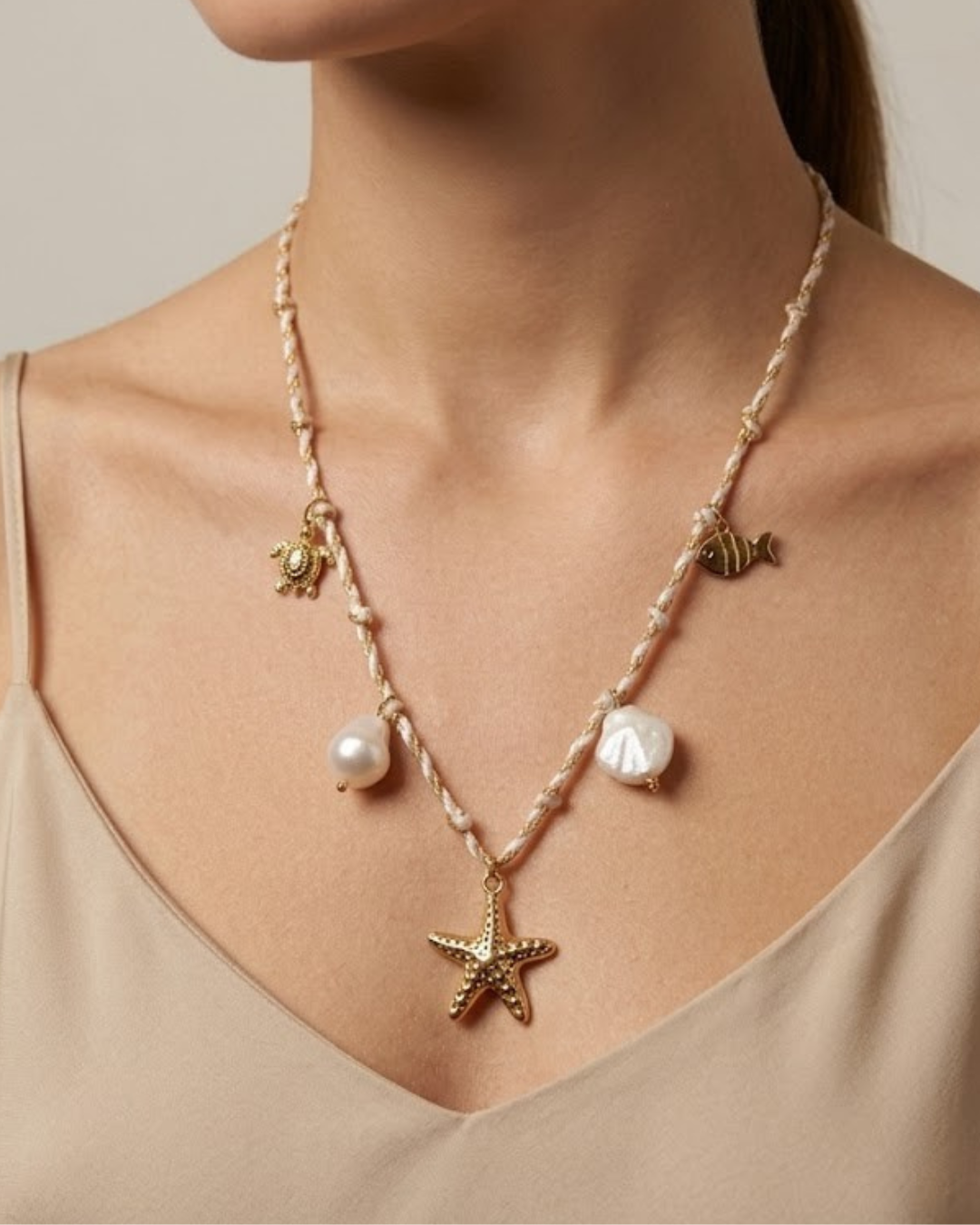 Modelo posando con collar de estrella de mar dorada y perlas