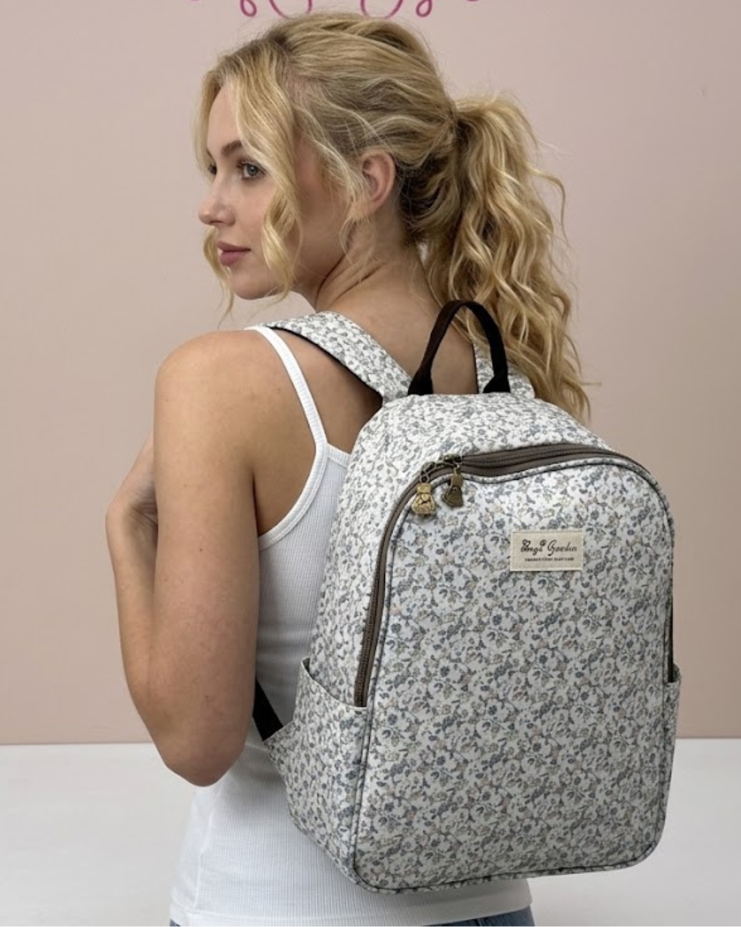 Chica rubia posando de espaldas con la mochila nevera térmica de flores silvestres Bags Garden disponible en Narella