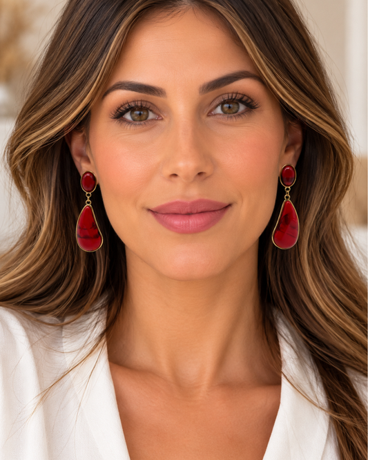Modelo de frente con pendientes largos rojos y dorados de dos piezas.