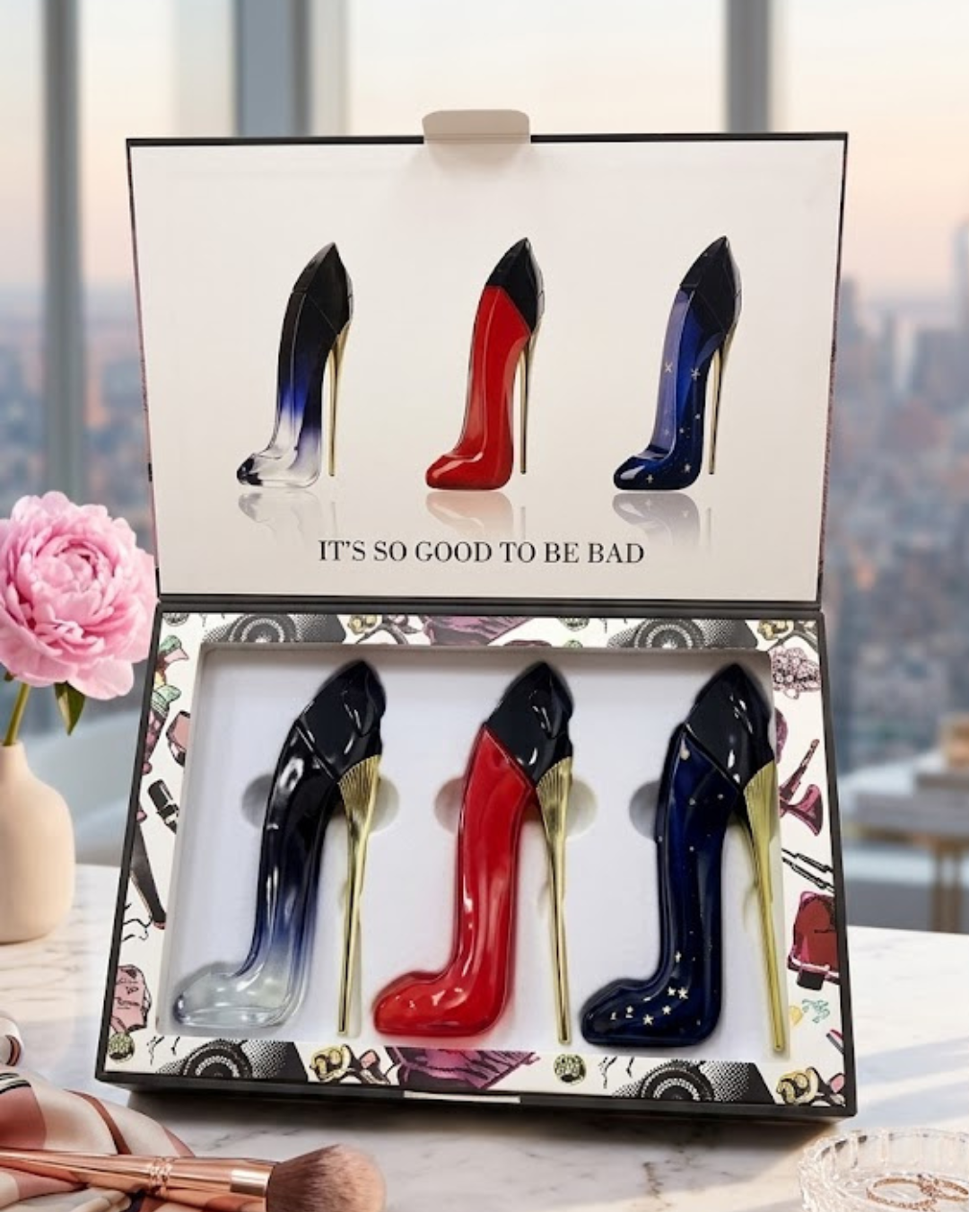 Estuche de regalo de perfumes con forma de tacón alto en color azul degradado, rojo y azul noche sobre tocador de mármol