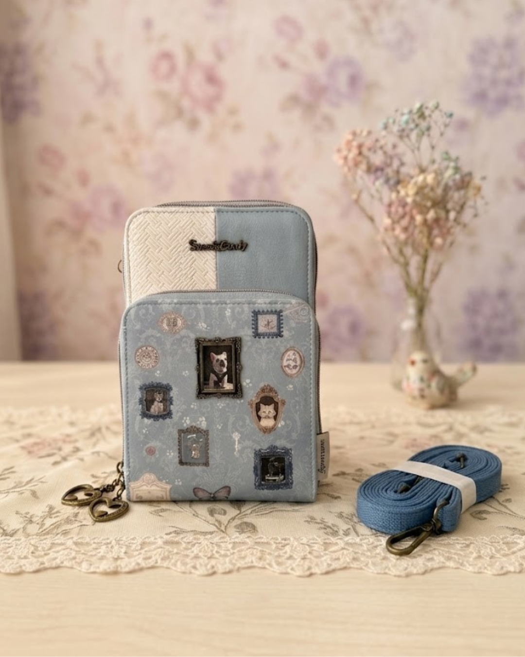 Bolso portamóvil Sweet Candy azul vintage con billetero, marco metálico de perrito y asa bandolera sobre mesa rústica