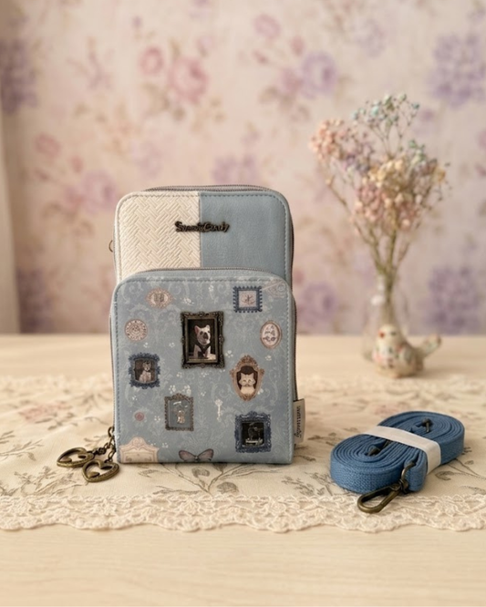Bolso portamóvil Sweet Candy azul vintage con billetero, marco metálico de perrito y asa bandolera sobre mesa rústica