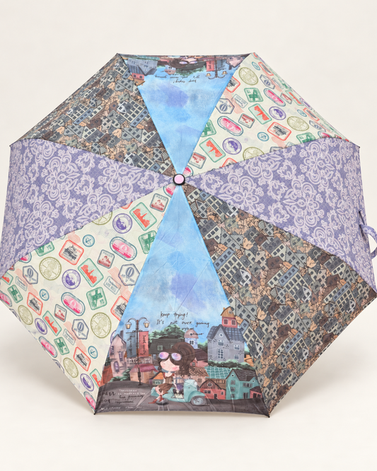 Paraguas plegable Sweet Candy abierto de perfil con ilustración de chica junto a una moto turquesa, casas de colores y mango lila con cinta.
