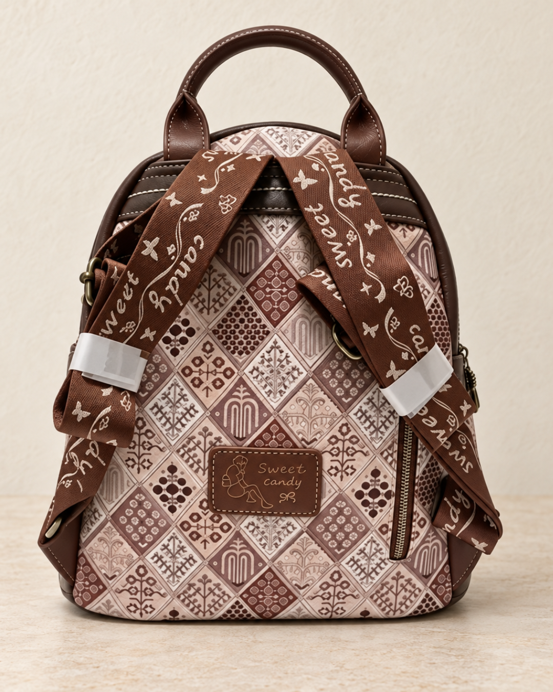 Parte trasera de mochila Sweet Candy con estampado geométrico en tonos marrones y beige, correas regulables y bolsillo con cremallera.