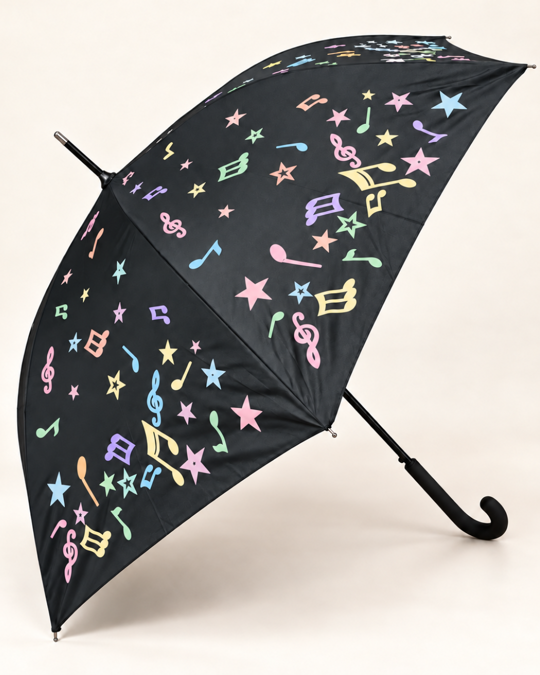 Representación del paraguas negro con notas musicales y estrellas en tonos pastel para ilustrar su cambio de color al mojarse.