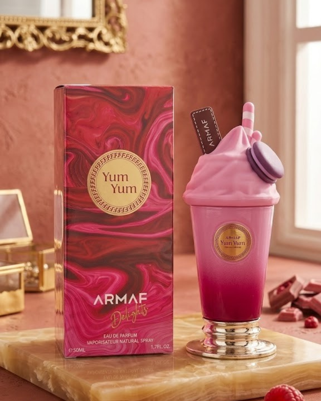 Perfume Armaf Delights Yum Yum Eau de Parfum de 50ml con frasco rosa en forma de helado y su caja fucsia.
